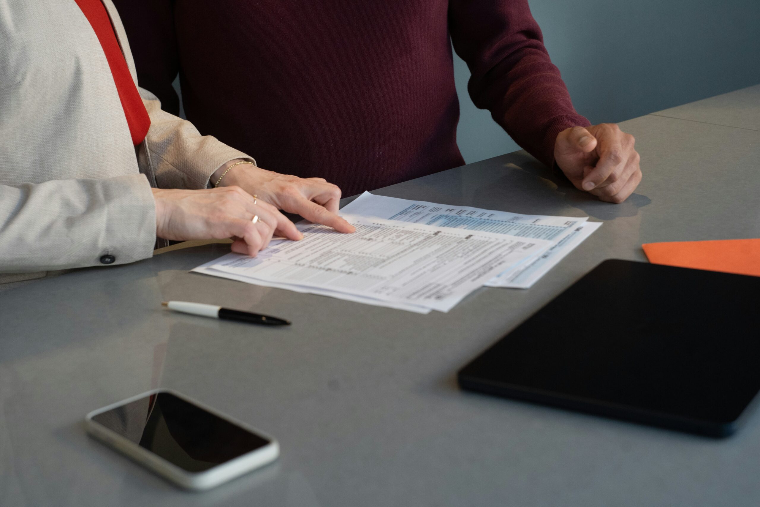Two people reviewing documents at a table.